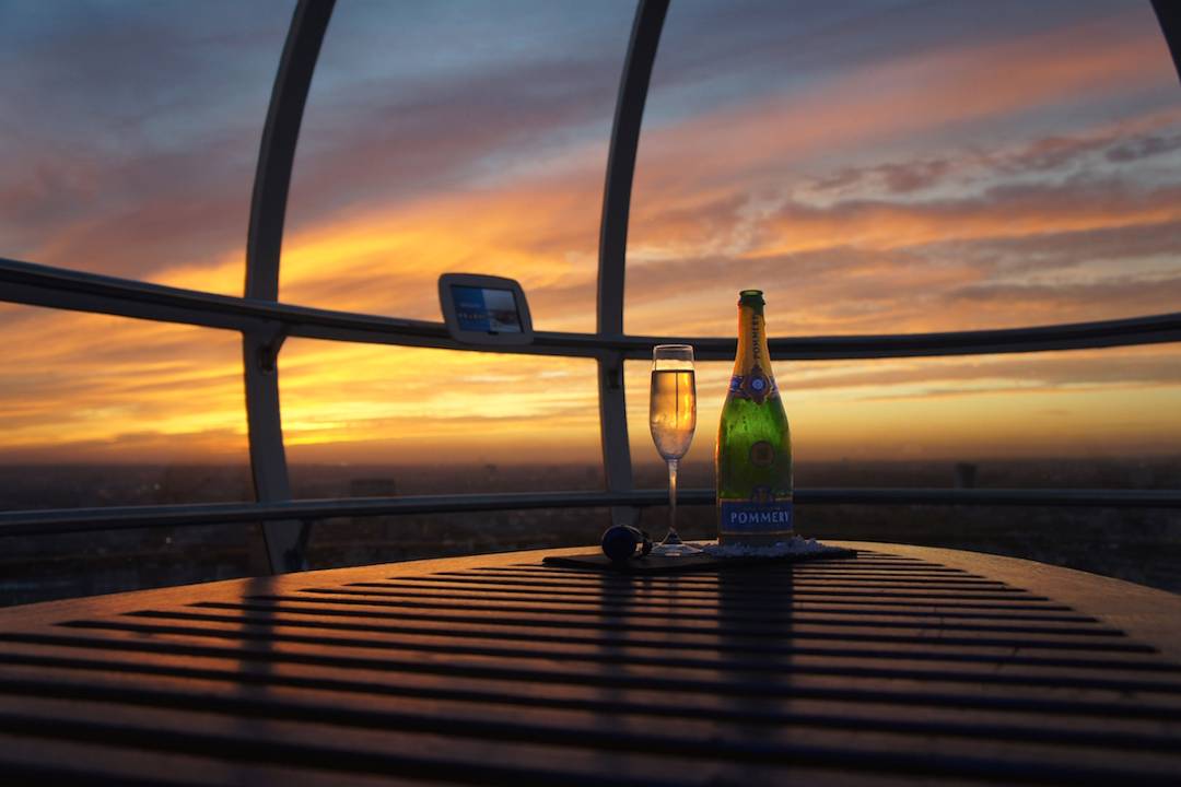 A photo of a bottle and glass of Champagne in a London Eye capsule.